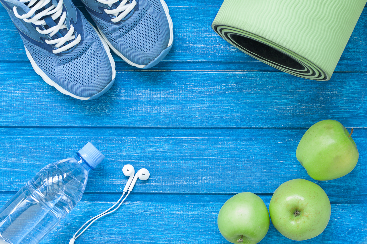 Flat-lay-sport-shoes,-bottle-of-water,-mat-and-earphones