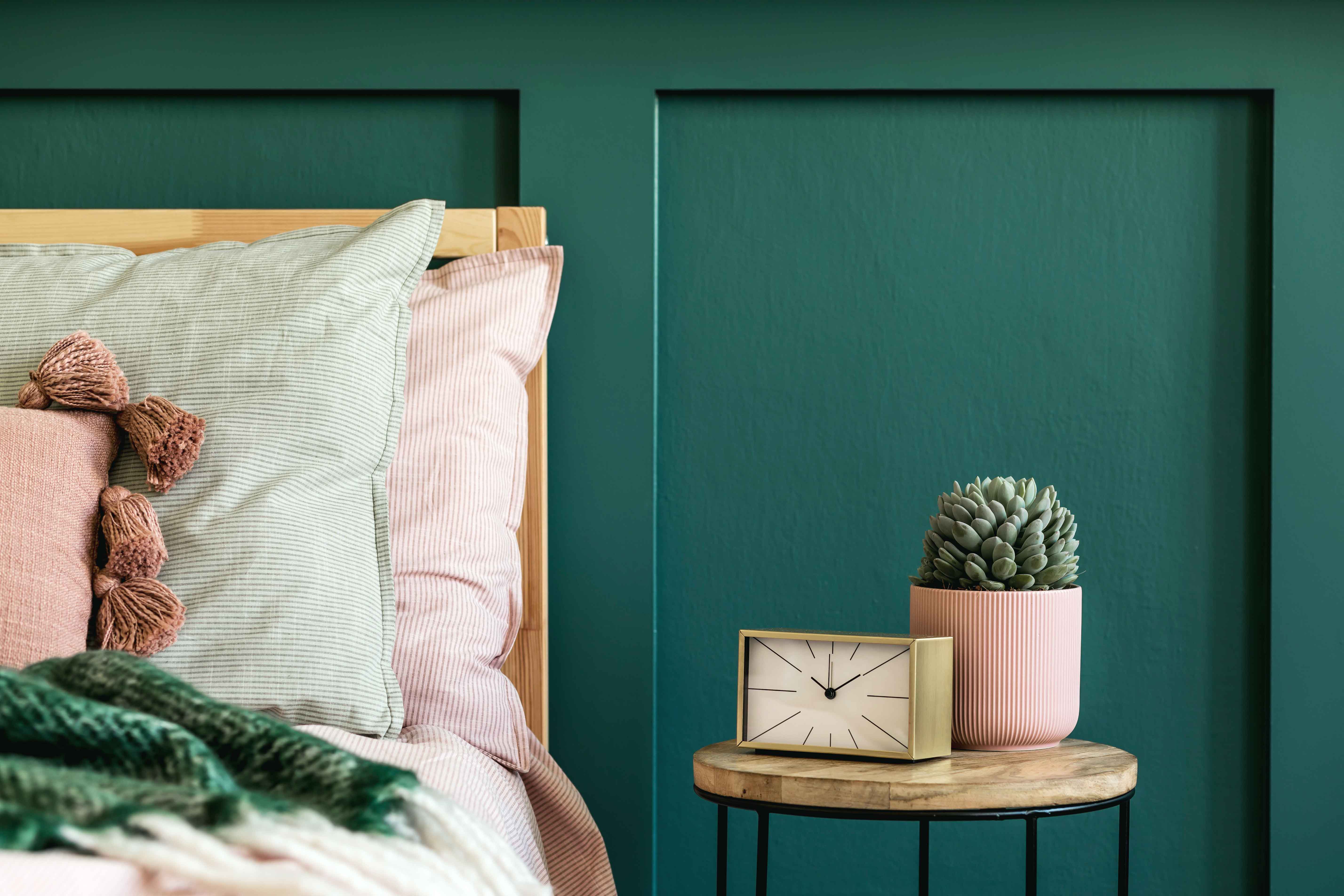 Stylish-bedroom-interior-with-design-coffee-table-plant-gold-clock-and-elegant-personal-accessories